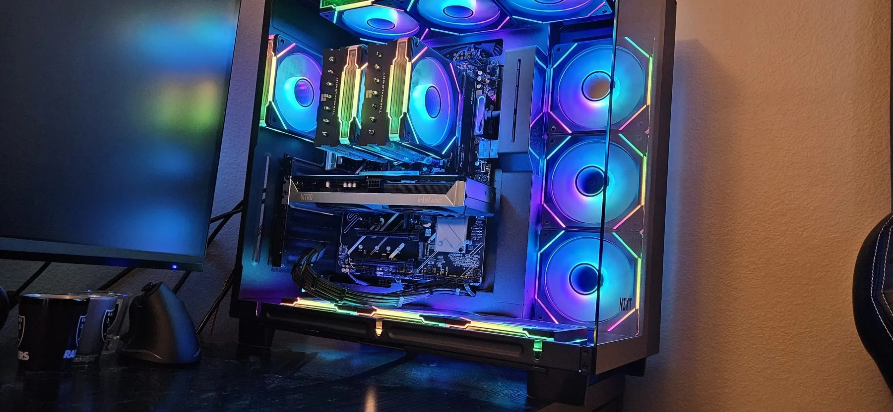 The AM5 build with the Arc B580, lit blue with rainbow accents